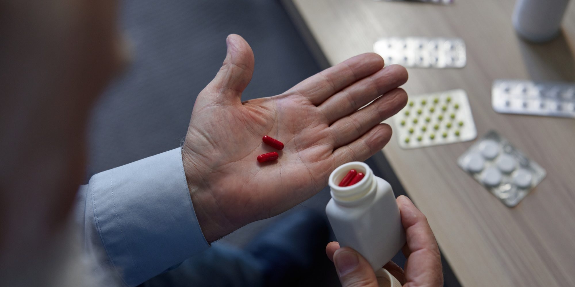 Medical pills tablets and capsules in senior man hand